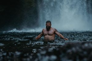 A man enjoys a refreshing swim near a waterfall in Cascade Locks, Oregon.