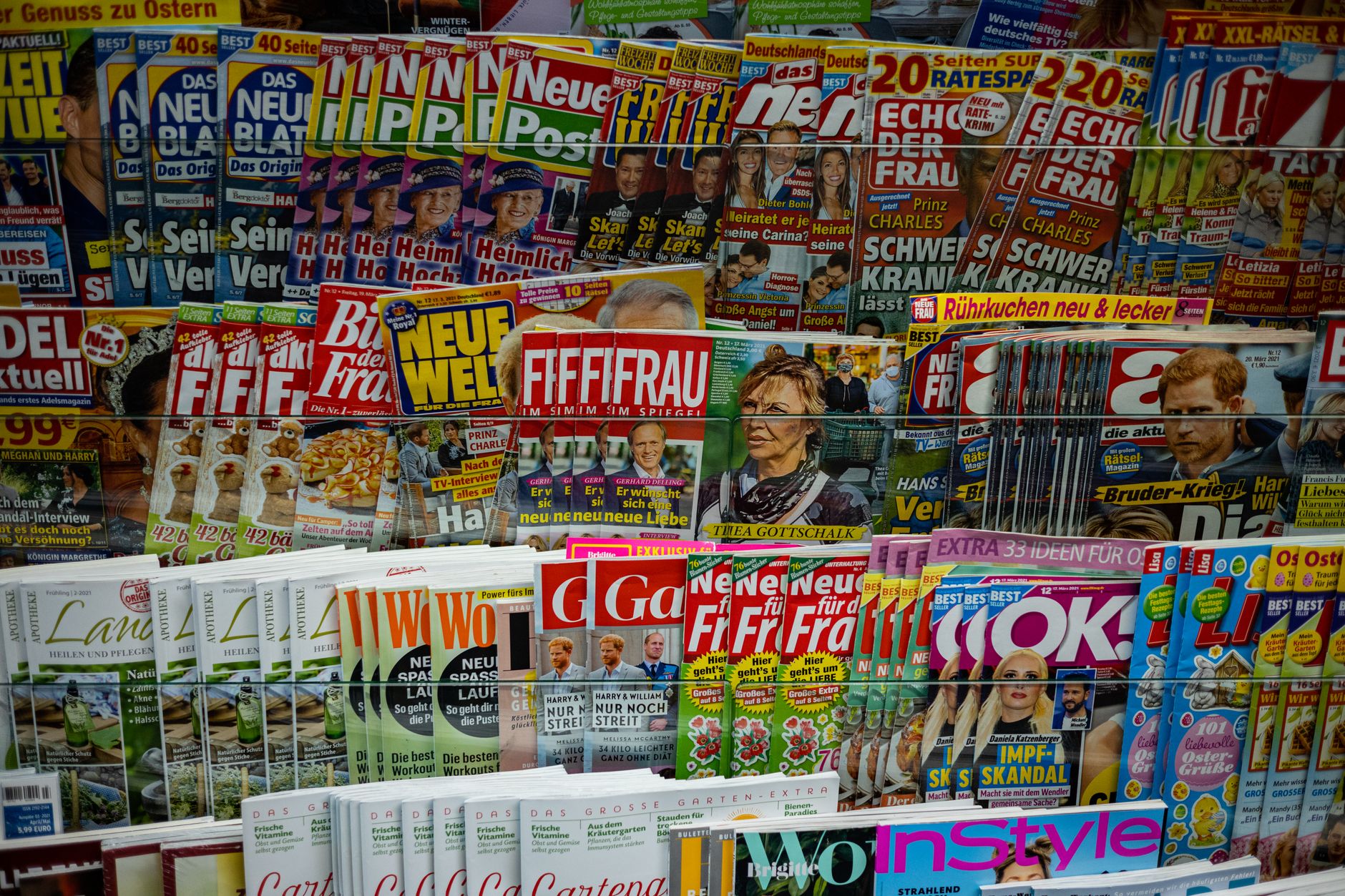A vibrant display of magazines in a newsstand, showcasing various colorful covers and headlines.