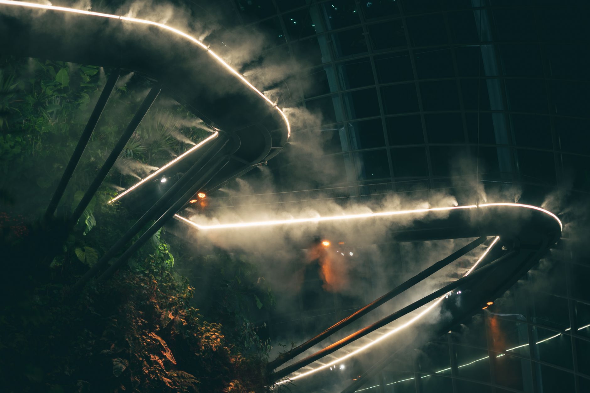 Misty atmosphere inside Gardens by the Bay, showcasing greenery and modern architecture.
