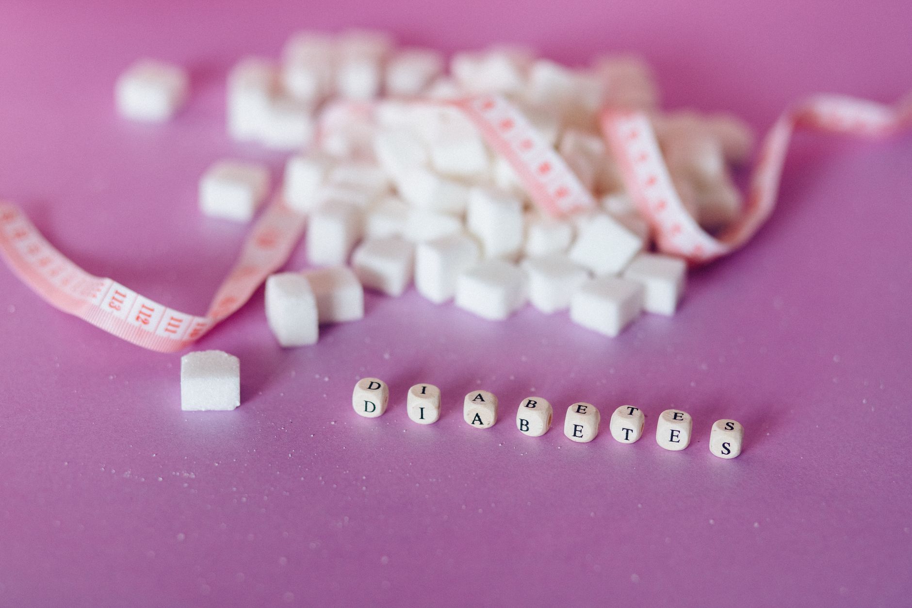 Still life of sugar cubes and diabetes concept with a tape measure, highlighting health awareness.