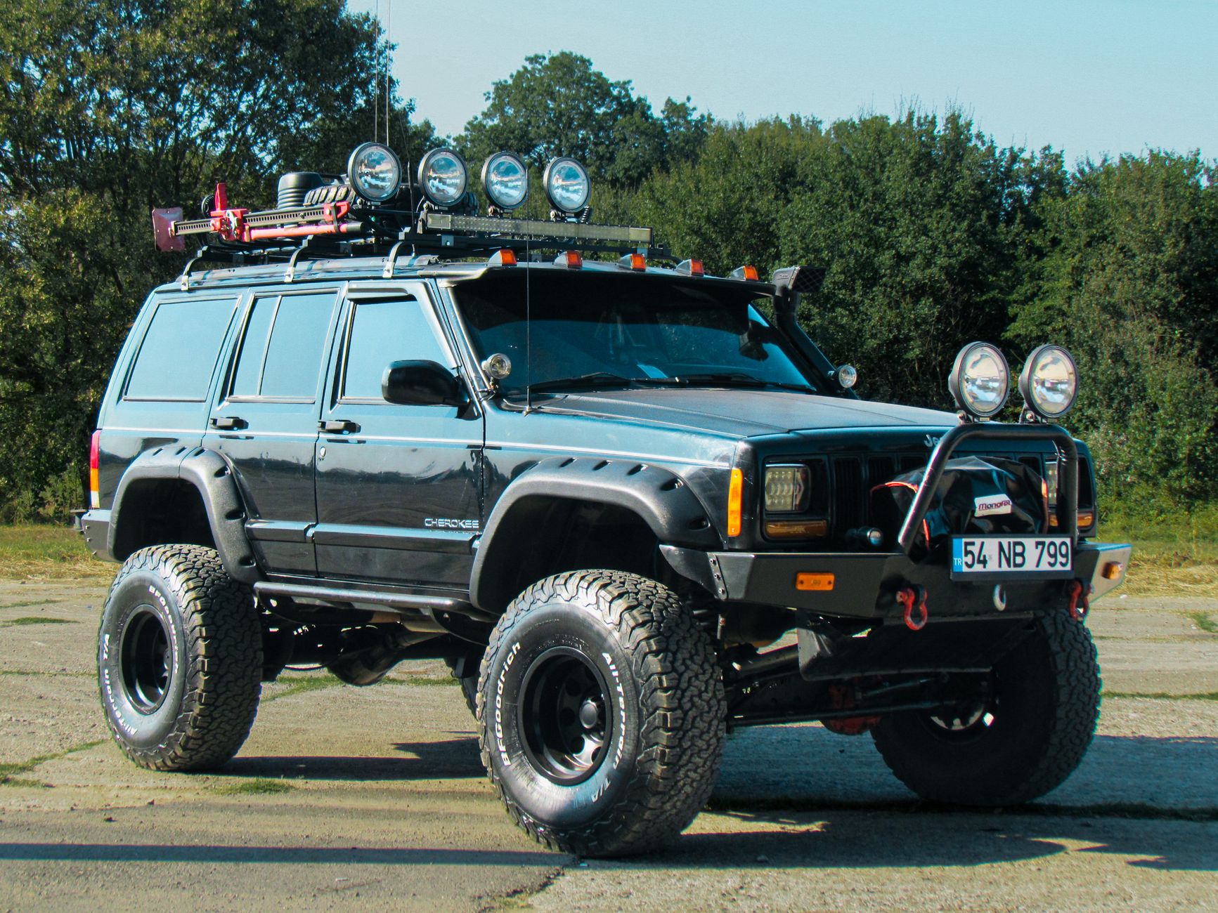 An off-road SUV with custom modifications parked outdoors, featuring unique lighting and suspension.