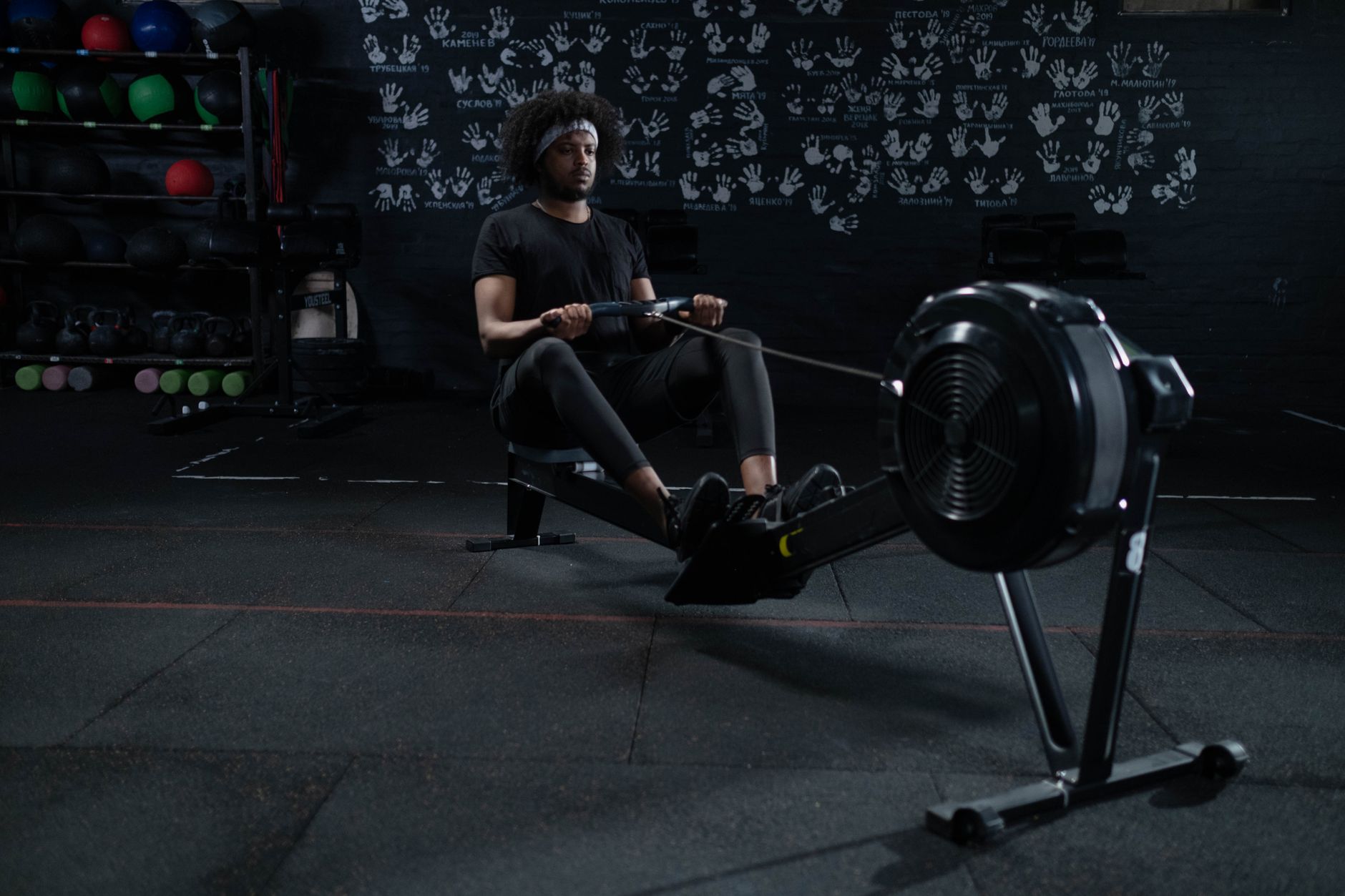 A man intensely working out on a rowing machine in a gym, promoting fitness and wellness.